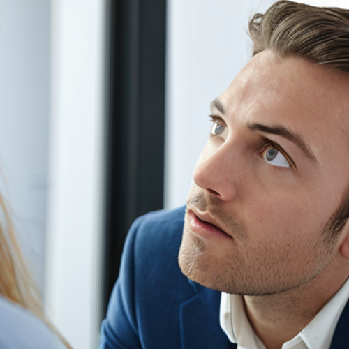 Home 11 **Image Prompt:** Close-up of a person attentively listening to a digital marketing expert during a meeting, showcasing active listening with subtle head nods and engaged eye contact. Background: a modern office setting.